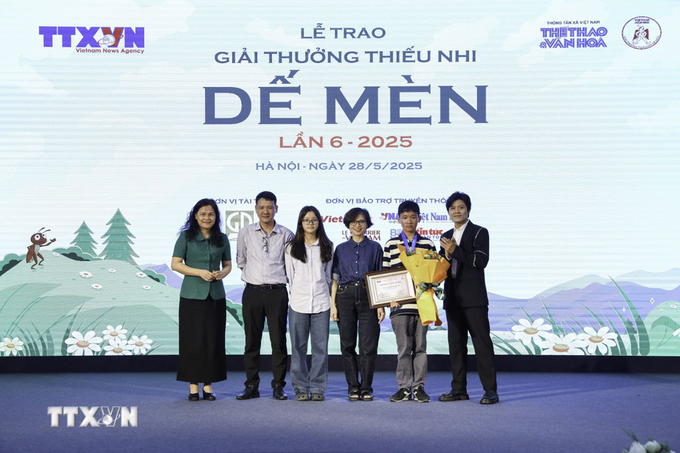 Phó Tổng Giám đốc TTXVN Nguyễn Thị Sự và nhạc sỹ Nguyễn Văn Chung (Đại sứ truyền cảm hứng Dế Mèn) lên trao giải "Khát vọng Dế Mèn" thứ ba cho các tác giả. (Ảnh: Lê Đông/TTXVN)