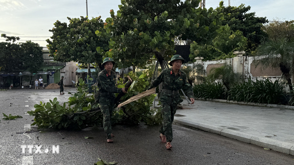 Lực lượng quân sự thu dọn cây xanh ngã trên đường Độc Lập, phường Tuy Hòa. (Ảnh: Tường Quân/TTXVN)