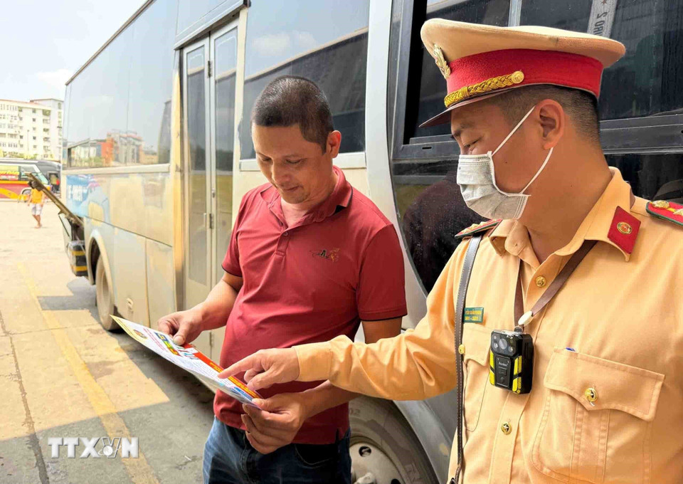 Cán bộ, chiến sỹ đội CSGT số 6 tuyên truyền đảm bảo an toàn giao thông đối với các tài xế xe khách tại khu vực Bến xe Mỹ Đình. (Ảnh: Phạm Kiên/TTXVN)