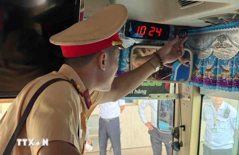 Cán bộ, chiến sỹ đội CSGT số 6 kiểm tra camera giám sát hành trình đối với xe khách. (Ảnh: Phạm Kiên/TTXVN)