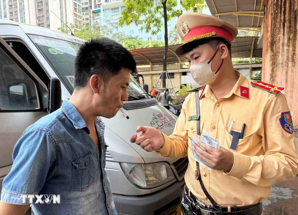 CSGT cho các tài xế xe khách kiểm tra nhanh ma túy qua việc ngậm ống để lấy nước bọt. (Ảnh: Phạm Kiên/TTXVN)