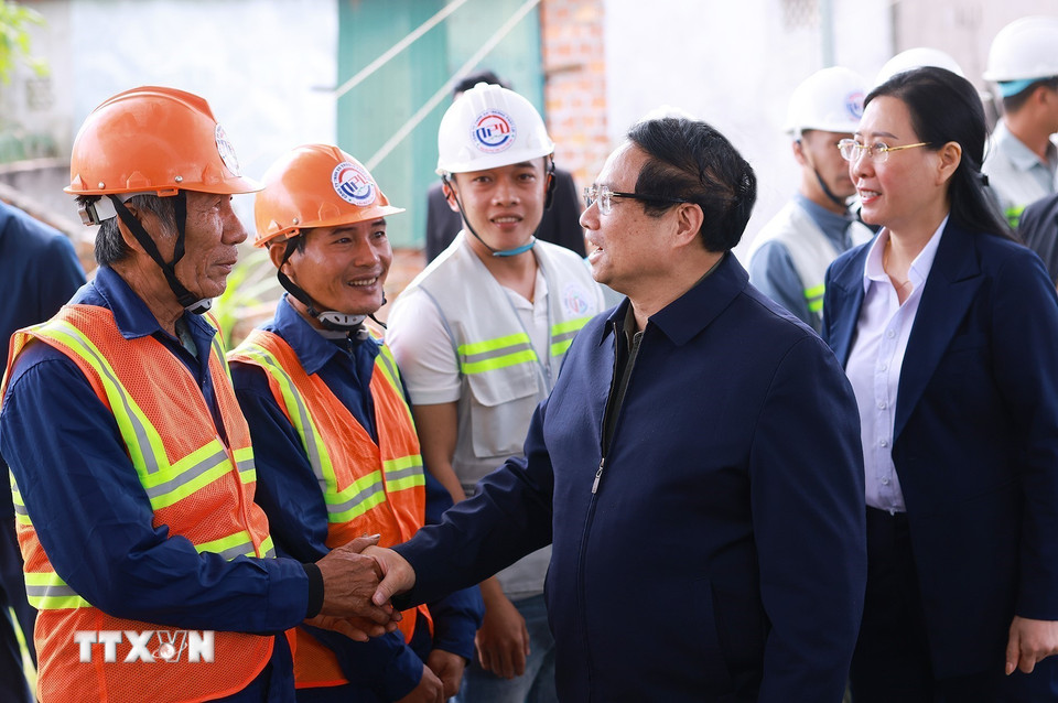 Thủ tướng Phạm Minh Chính với công nhân thi công dự án đường ven biển Dung Quất/Sa Huỳnh. (Ảnh: Dương Giang-TTXVN)