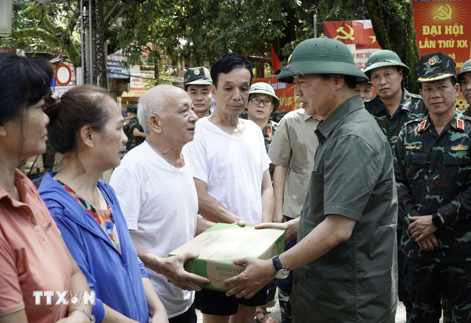 Phó Thủ tướng Trần Hồng Hà tặng quà các hộ bị ngập hoàn toàn. (Ảnh: Chu Hiệu/TTXVN)