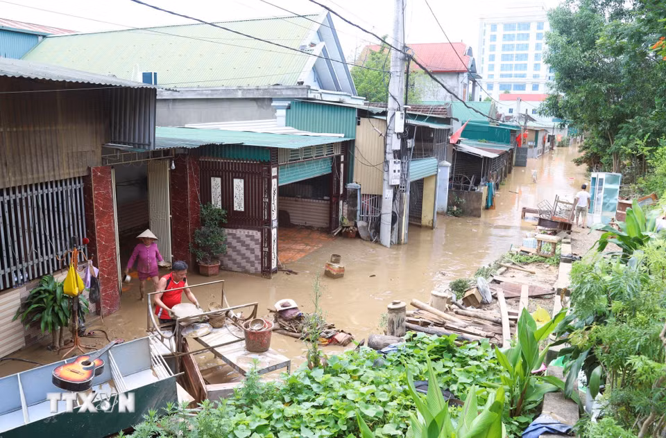 Người dân xã Con Cuông, tỉnh Nghệ An dọn nhà cửa, đồ đạc, vật dụng và môi trường cảnh quang khu dân cư khi nước lũ giảm mạnh. (Ảnh: Xuân Tiến/TTXVN)
