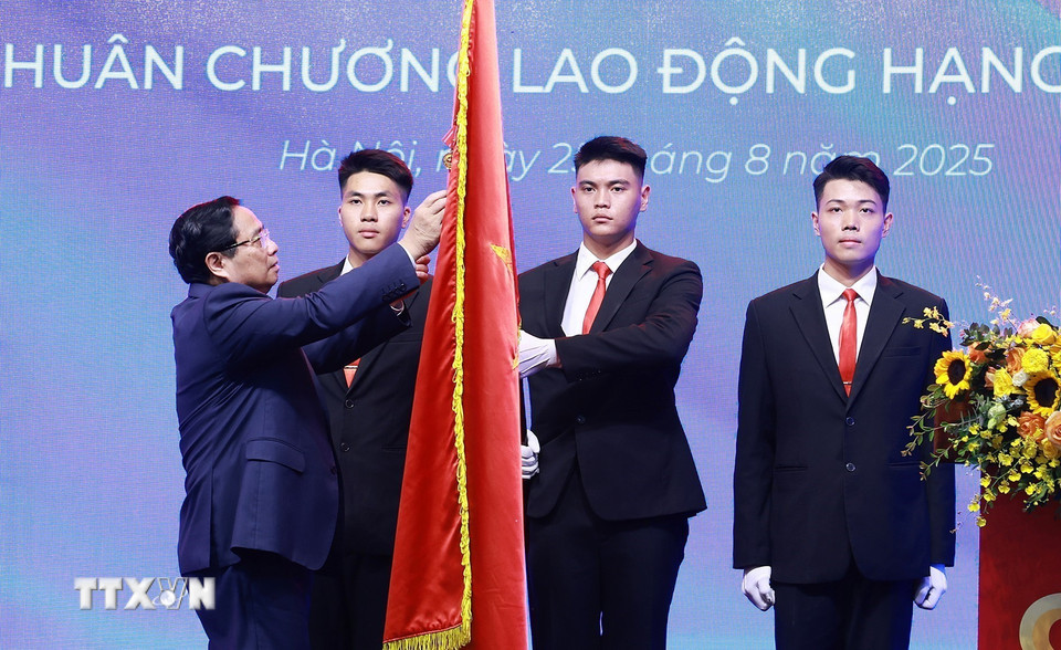 Thủ tướng Phạm Minh Chính gắn Huân chương Lao động hạng Nhất lên Cờ truyền thống của ngành Tư pháp. (Ảnh: Dương Giang/TTXVN)