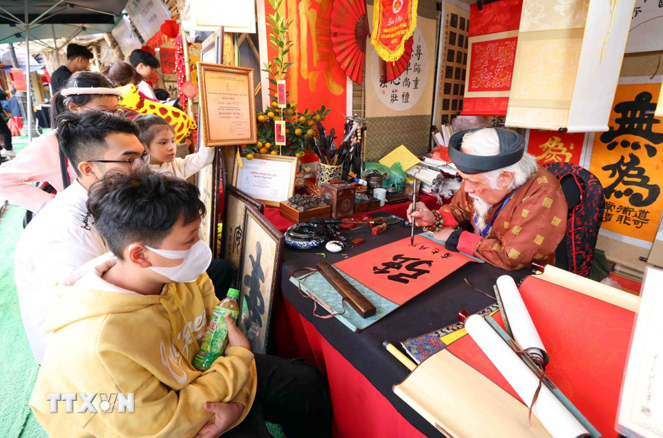 Xin chữ đầu năm tại khu di tích Văn Miếu-Quốc Tử Giám với ước vọng con cái học hành, thi cử đỗ đạt và gặp nhiều may mắn cũng là nét đẹp truyền thống của người dân Thủ đô mỗi dịp du Xuân. (Ảnh: Phạm Kiên/TTXVN)