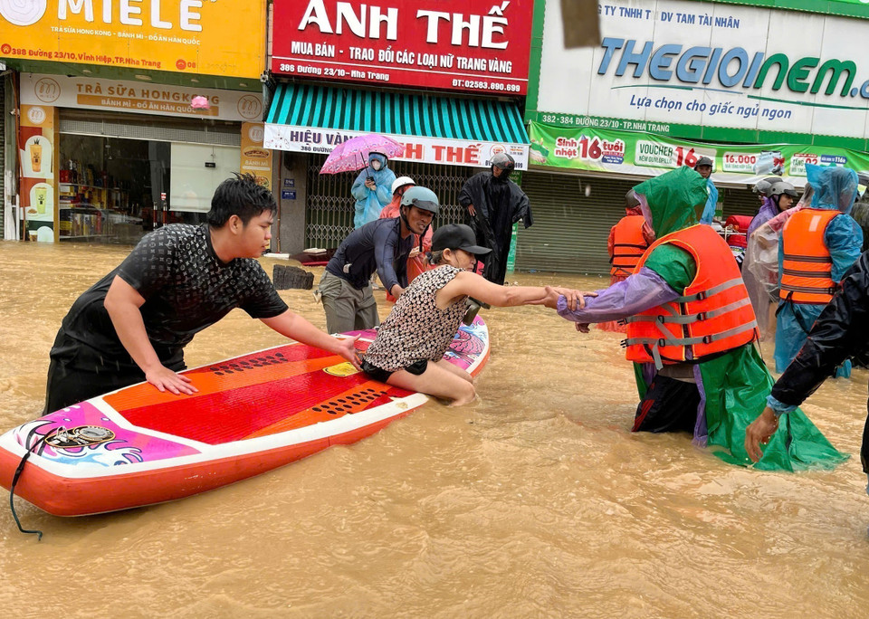 Sử dụng thuyền kayak đưa người dân vùng ngập lụt bị cô lập đến nơi an toàn. (Ảnh: Phan Sáu/TTXVN)