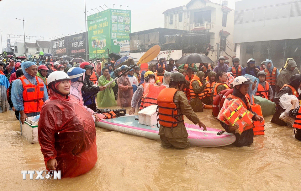Người dân ở phường Tây Nha Trang được lực lượng chức năng sơ tán khỏi vùng ngập lụt. (Ảnh: Phan Sáu/TTXVN)