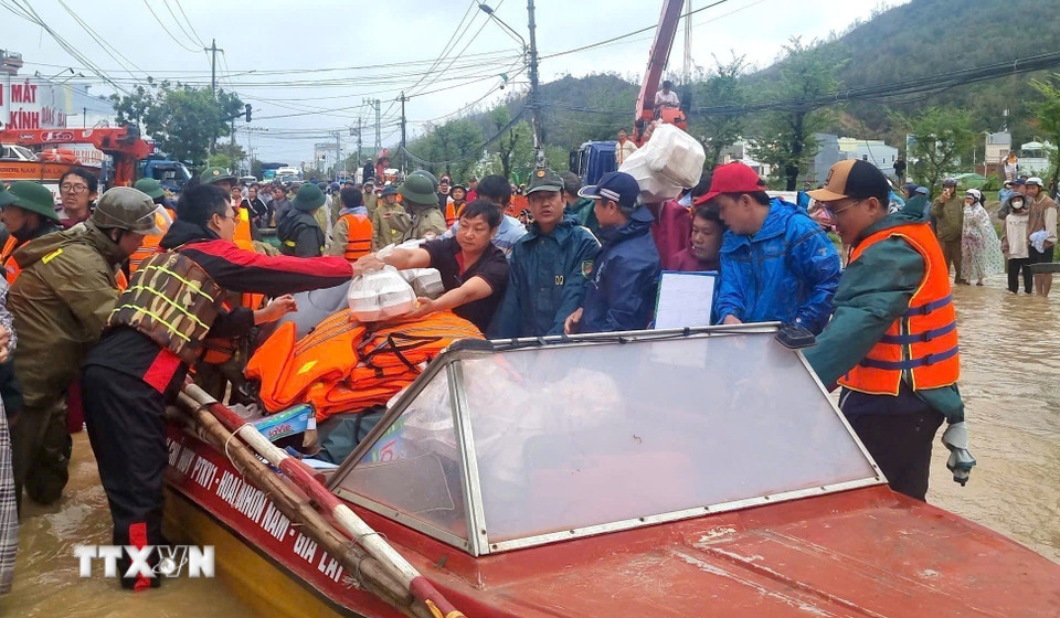 Lực lượng chức năng của tỉnh Gia Lai tăng cường nhân-vật lực, tập trung di dời người dân, vận chuyển lương thực, nhu yếu phẩm cần thiết cho người dân trong vùng ngập lụt. (Ảnh: Quang Thái/TTXVN)