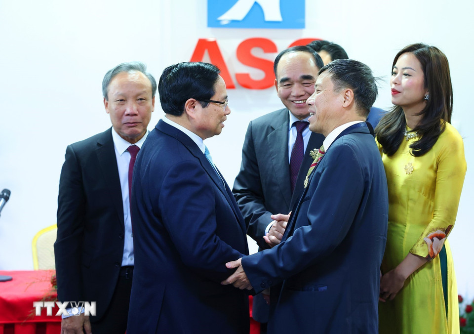 Thủ tướng Phạm Minh Chính thăm hỏi đại diện cộng đồng người Việt Nam kinh doanh tại Trung tâm thương mại ASG. (Ảnh: Dương Giang/TTXVN)