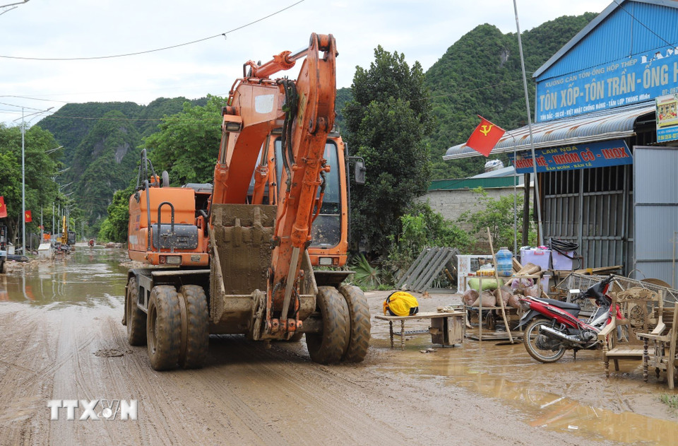 Máy cẩu được huy động tham gia giải phóng các điểm ngập trên quốc lộ 7. (Ảnh: Xuân Tiến/TTXVN)