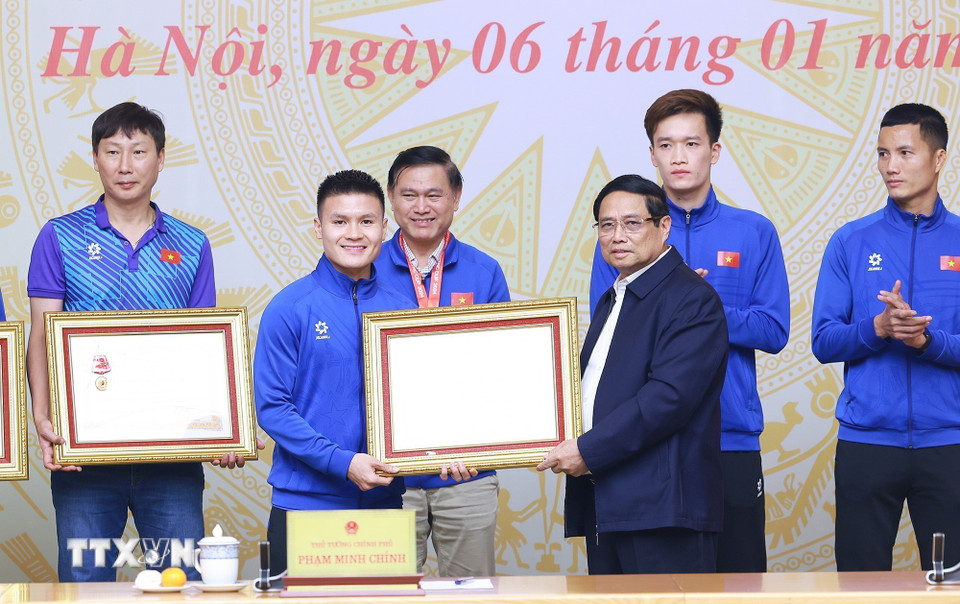 Thủ tướng Phạm Minh Chính trao Huân chương Lao động hạng Ba cho cầu thủ Nguyễn Quang Hải. (Ảnh: Dương Giang/TTXVN)