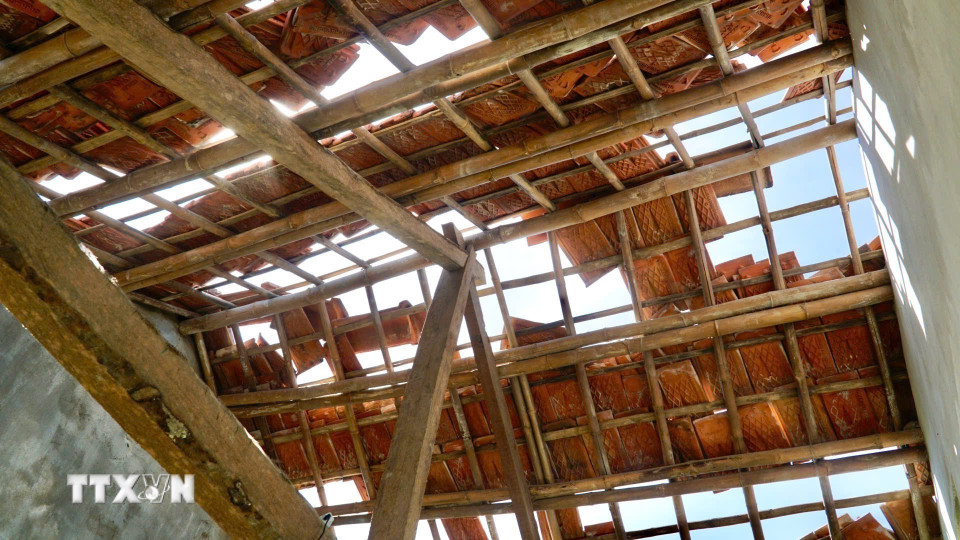 Gió giật mạnh làm hư hỏng mái nhà của người dân làng chài dưới chân cầu Đề Gi. (Ảnh: Sỹ Thắng/TTXVN)