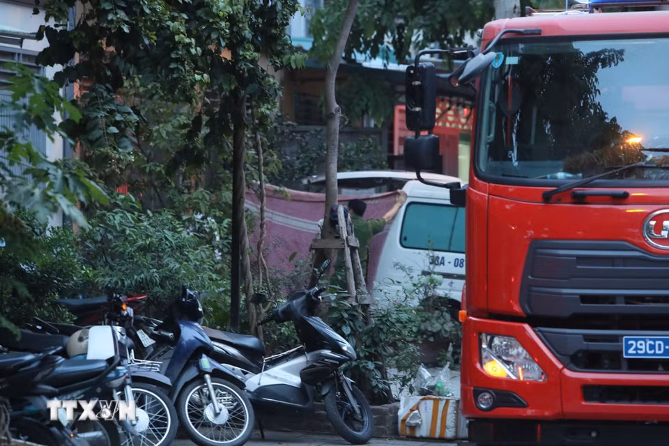 Lực lượng chức năng tiến hành đưa thi thể nạn nhân ra khỏi hiện trường. (Ảnh: Phạm Kiên/TTXVN)