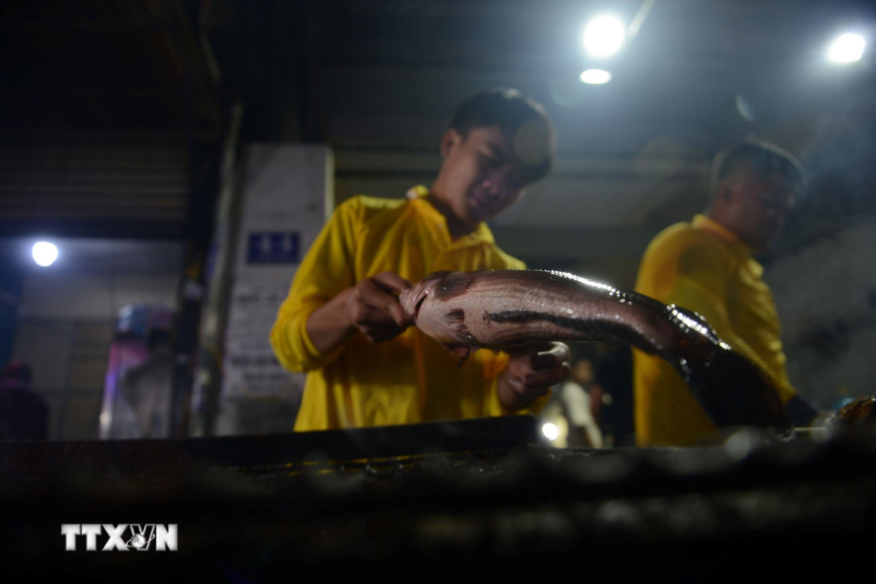 Tối 6/2, phố cá lóc nướng trên đường Tân Kỳ-Tân Quý luôn rực lửa, khói nghi ngút. (Ảnh: Mạnh Linh/TTXVN)