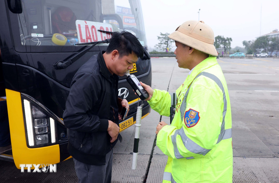Cán bộ, chiến sỹ CSGT đội 3 (Phòng Hướng dẫn tuần tra, kiểm soát giao thông đường bộ, đường sắt, Cục CSGT) kiểm tra nồng độ cồn đối với tài xế xe khách trên tuyến cao tốc Pháp Vân-Cầu Giẽ. (Ảnh: Phạm Kiên/TTXVN)