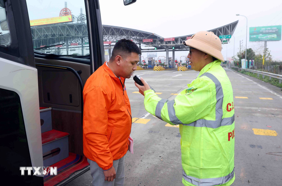 Cán bộ, chiến sỹ CSGT đội 3 (Phòng Hướng dẫn tuần tra, kiểm soát giao thông đường bộ, đường sắt, Cục CSGT) kiểm tra nồng độ cồn đối với tài xế xe khách trên tuyến cao tốc Pháp Vân-Cầu Giẽ. (Ảnh: Phạm Kiên/TTXVN)