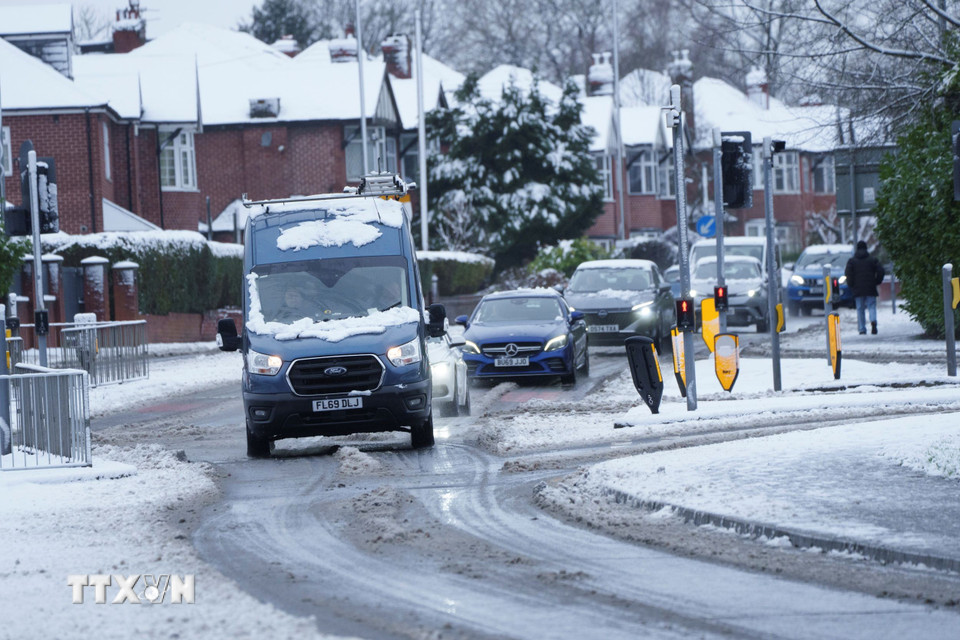 Các phương tiện di chuyển trên đoạn đường phủ đầy tuyết tại Manchester, Anh ngày 5/1/2025. (Ảnh: THX/TTXVN)