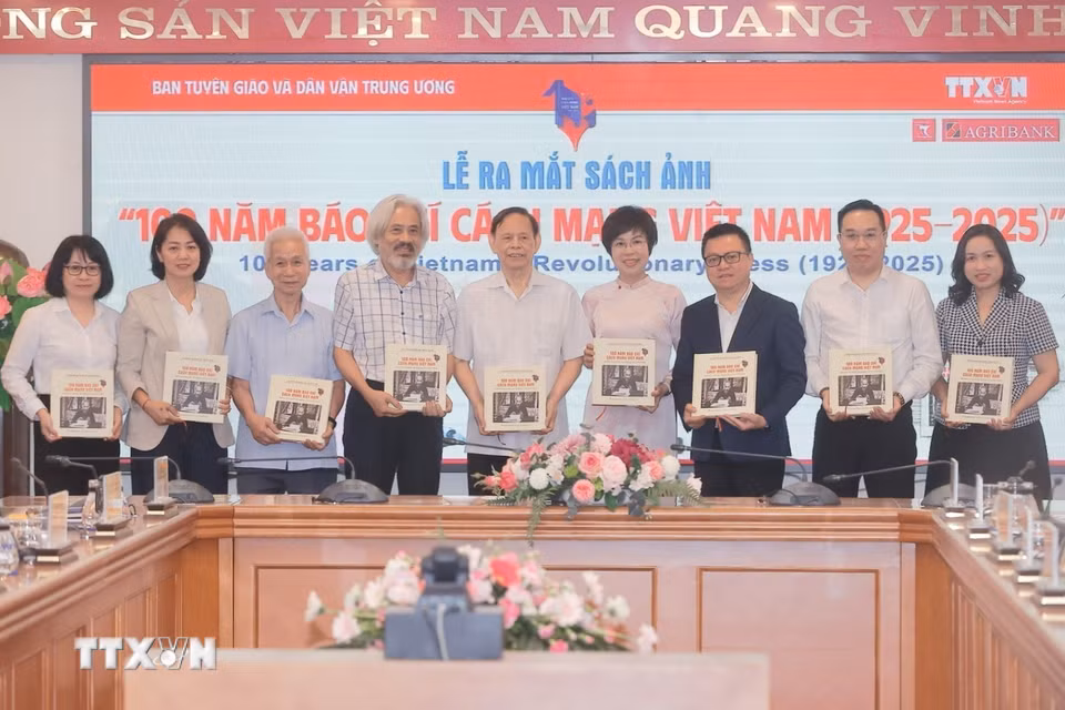 Tổng giám đốc TTXVN Vũ Việt Trang tặng sách ảnh cho các đại biểu. (Ảnh: Minh Quyết/TTXVN)