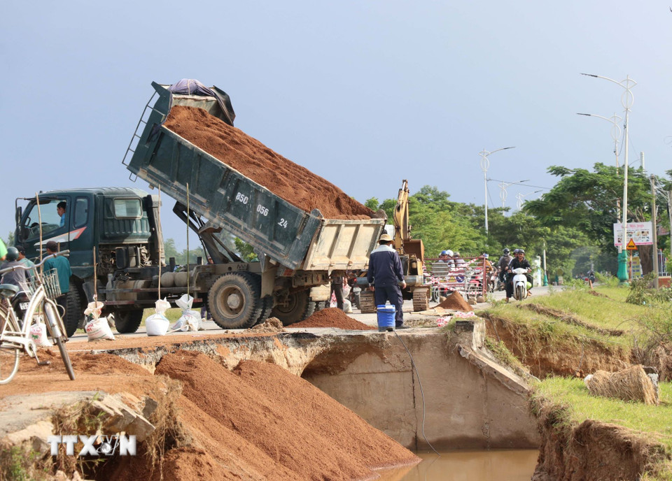 Đơn vị quản lý đường bộ tỉnh Khánh Hòa khắc phục sạt lở do mưa lũ tại tuyến đường 703. (Ảnh: Công Thử/TTXVN)