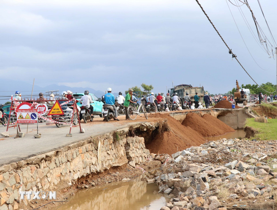 Đơn vị quản lý đường bộ tỉnh Khánh Hòa khắc phục sạt lở do mưa lũ tại tuyến đường 703. (Ảnh: Công Thử/TTXVN)