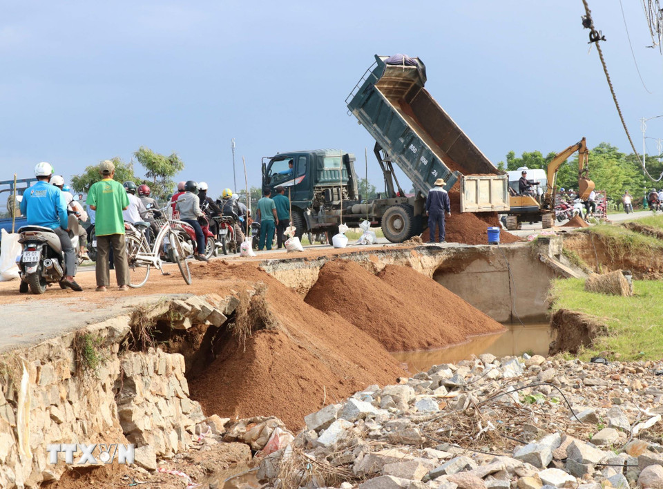 Đơn vị quản lý đường bộ tỉnh Khánh Hòa khắc phục sạt lở do mưa lũ tại tuyến đường 703. (Ảnh: Công Thử/TTXVN)