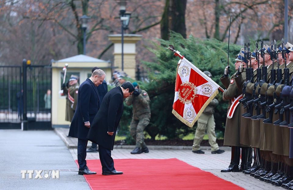 Thủ tướng Phạm Minh Chính và Thủ tướng Cộng hòa Ba Lan Donald Tusk duyệt đội danh dự. (Ảnh: Dương Giang/TTXVN)