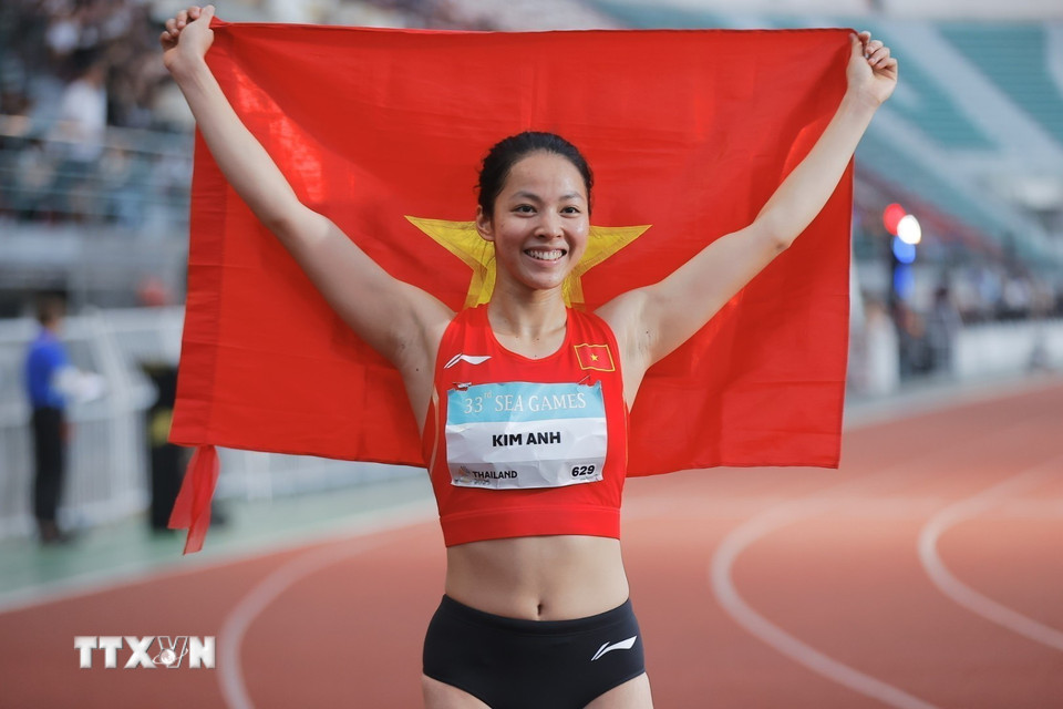 Bùi Kim Anh giương cao lá cờ Tổ quốc sau khi xuất sắc vượt qua mức xà 1,86m tại SEA Games 33. (Ảnh: Minh Quyết/TTXVN)