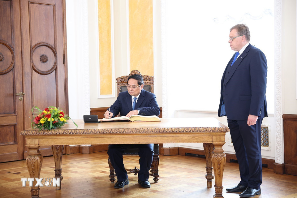 Thủ tướng Phạm Minh Chính ký sổ lưu niệm. (Ảnh: Dương Giang/TTXVN)