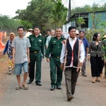 Già làng, người có uy tín trong cộng đồng và lực lượng biên phòng “đi từng ngõ, gõ từng nhà” để hướng dẫn người dân quy trình bỏ phiếu bầu cử đúng theo quy định. (Ảnh: Hồng Điệp/TTXVN)