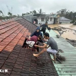 Lũ dâng cao, người dân phải phá mái nhà leo lên để tránh nguy hiểm ở Gia Lai. (Ảnh: TTXVN phát)