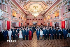 Các đại biểu và quan khách làm lễ chào cờ tại sự kiện. (Ảnh: TTXVN)