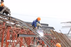 Không khí lao động tại công trường xây dựng cầu qua sông Tràng An, phường Hoa Lư ngày đầu năm mới. (Ảnh: Đức Phương/TTXVN)