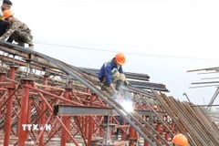 Không khí lao động tại công trường xây dựng cầu qua sông Tràng An, phường Hoa Lư ngày đầu năm mới. (Ảnh: Đức Phương/TTXVN)