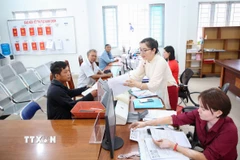 Công tác tiếp nhận, giải quyết thủ tục hành chính theo cơ chế “một cửa”, “một cửa liên thông” tại Trung tâm phục vụ Hành chính công xã Tân Đông, tỉnh Tây Ninh. (Ảnh: Giang Phương/TTXVN)