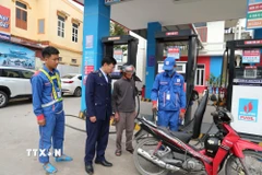 Cán bộ Đội Quản lý thị trường số 6, Chi cục QLTT Thanh Hóa có mặt tại cửa hàng xăng dầu để nắm bắt tình hình cung ứng, ổn định thị trường khi giá xăng biến động. (Ảnh: Khiếu Tư/TTXVN)