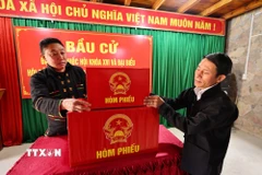 Sắp xếp hòm phiếu, trang trí hội trường, dán danh sách bầu cử tại nhà văn hóa thôn Lô Lô Chải, xã Lũng Cú, tỉnh Tuyên Quang. (Ảnh: Minh Đức/TTXVN)