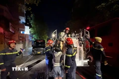 Nhiều người bên trong căn nhà được giải cứu. (Ảnh: TTXVN phát)