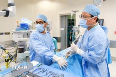 Các bác sỹ Bệnh viện FV tiến hành phẫu thuật dẫn lưu ápxe và nạo sạch ổ nhiễm trùng cho bệnh nhi. (Ảnh: TTXVN phát)