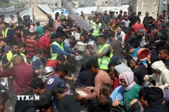 Người dân Palestine nhận thức ăn cứu trợ tại thành phố Gaza ngày 2/5/2025. (Ảnh: THX/TTXVN)