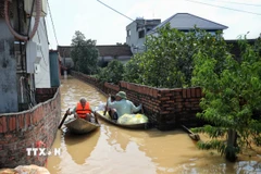 Thôn Phú Cốc, xã Hợp Thịnh, bị ngập nặng, người dân phải dùng thuyền đi lại. (Ảnh: Danh Lam/TTXVN)
