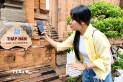 Du khách quét QR tìm hiểu thông tin tại Di tích quốc gia đặc biệt Tháp Bà Pô Nagar (phường Bắc Nha Trang, Khánh Hòa). (Ảnh: Nguyễn Thành/TTXVN)