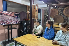 Đoàn viên thanh niên dân tộc thiểu số phường Mường Lay theo dõi truyền hình trực tiếp Đại hội XIV của Đảng qua tivi. (Ảnh: TTXVN phát)