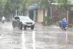 Người dân đi lại trong mưa lớn ở thành phố Đông Hà, tỉnh Quảng Trị. (Ảnh: Nguyên Lý/TTXVN)