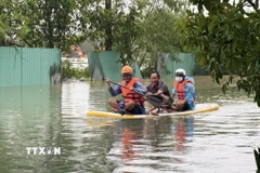 Dùng chèo súp chở người dân đến nơi an toàn. (Ảnh: Tường Quân/TTXVN)