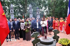 Phu nhân Ngô Phương Ly và Phu nhân Naly Sisoulith tặng hoa cho các sinh viên trường Đại học Hoa Lư sau buổi biểu diễn văn nghệ. (Ảnh: Minh Đức/TTXVN)