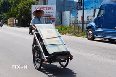 Nhọc nhằn vận chuyển hàng hóa bằng xích lô giữa nắng nóng gay gắt trên đường Đào Tấn, phường Thuận Hóa, thành phố Huế. (Ảnh: Nguyên Lý/TTXVN)