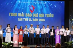 Ban tổ chức trao cúp và chứng nhận cho tác phẩm đạt giải Nhì. (Ảnh: Tường Vi/TTXVN)