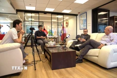 Phóng viên TTXVN tại Israel tác nghiệp khi Đại sứ Lý Đức Trung trao đổi với Chủ tịch Hội Hữu nghị Israel-Việt Nam Eyal Buvilski. (Ảnh: Phạm Hà/TTXVN)