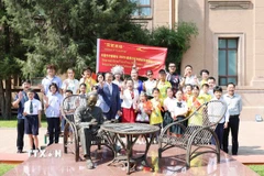 Thiếu nhi hai nước Việt-Trung cùng Lãnh đạo Đại sứ quán Việt Nam tại Trung Quốc chụp ảnh lưu niệm bên tượng đài Bác Hồ. (Ảnh: Công Tuyên/TTXVN)